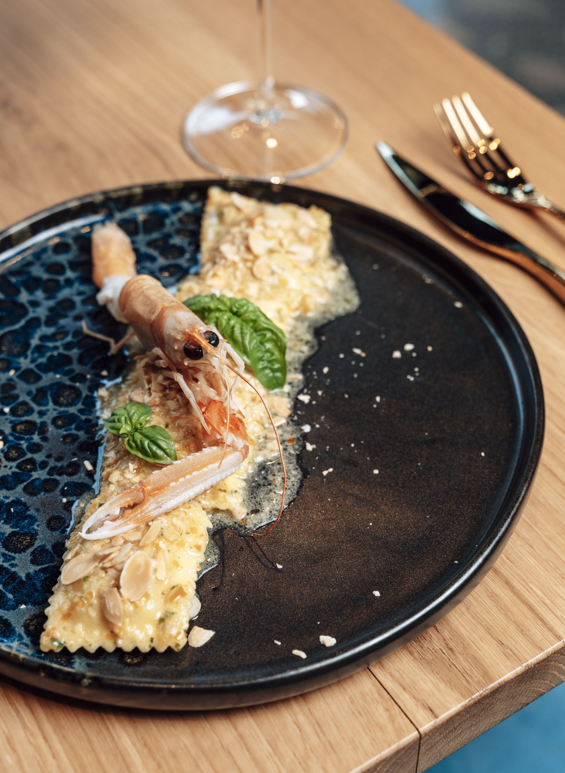 Raviolo con scampo su piatto nero
